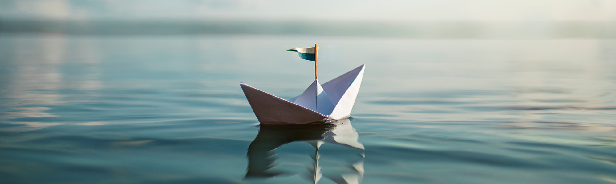 KJH-Leuchtturm-kleines-segelboot-aus-papier-auf-dem-wasser Kinder- und Jugendhospiz Leuchtturm kleines Segelboot aus Papier auf dem Wasser